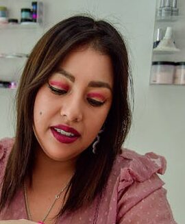 A female beautician performing a manicure at a nail salon, focusing on nail care and beauty.